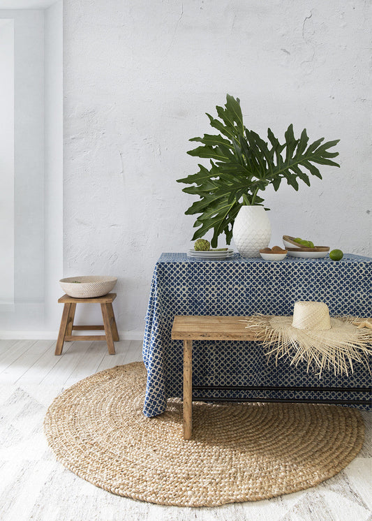 Indigo Tic Toc Tablecloth styled with a white vase and large tropical leaves against a neutral white wall